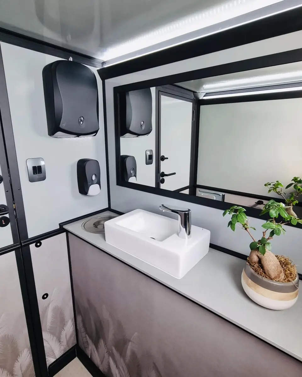 Restroom trailer vanity with vessel sink, mirror and paper towel dispenser